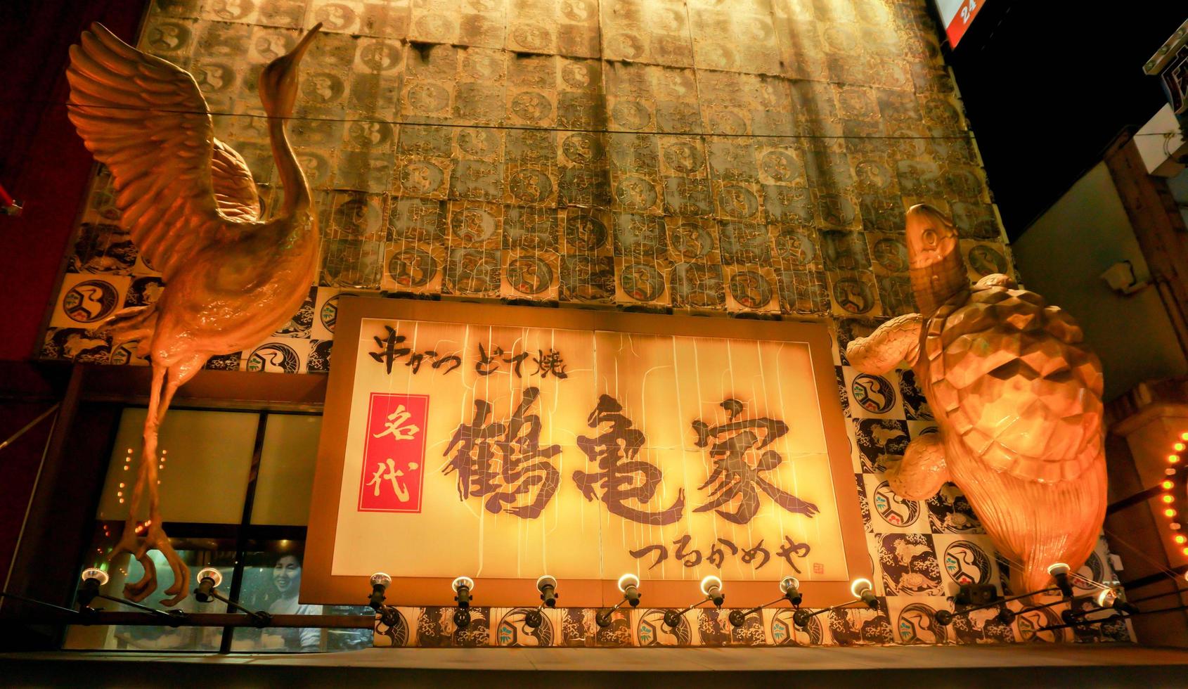 Osaka, Japan, 2018 - Japanese restaurant sign with Red crowned crane and turtle wood carving, One of beautiful restaurant sign at Shinsekai area of Osaka city photo