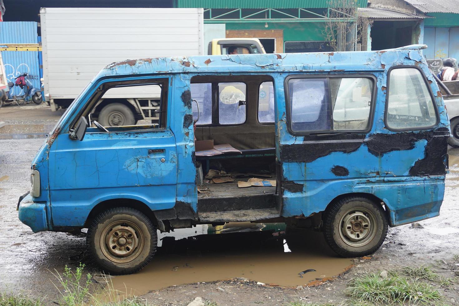 Indonesian public transportation, old and damaged blue angkot. photo