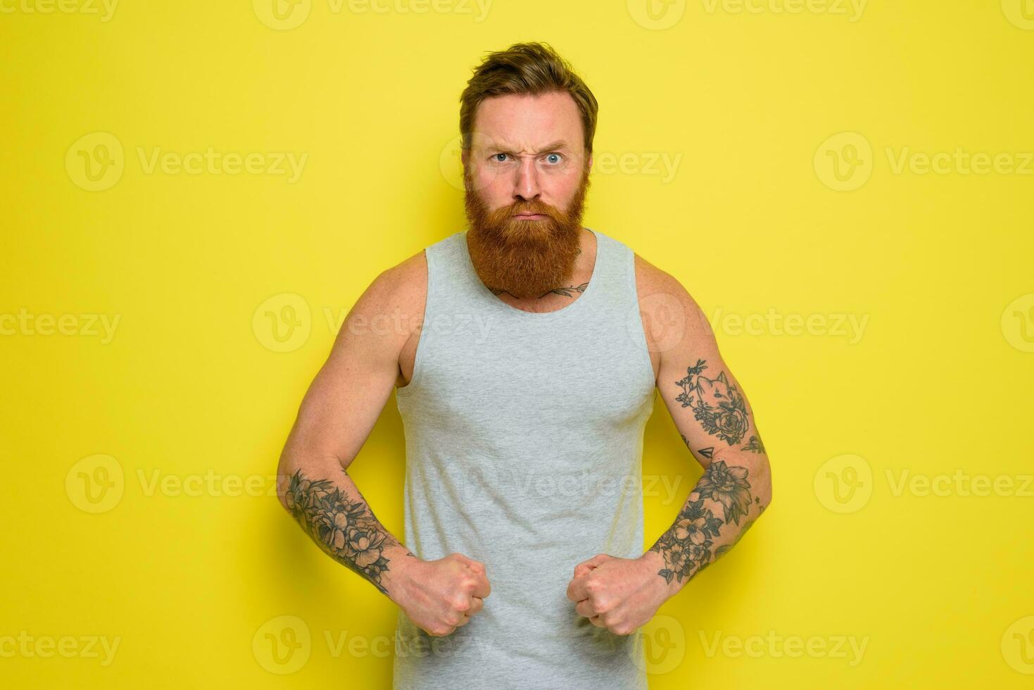 Man with beard and tattoos shows with pride his muscle photo
