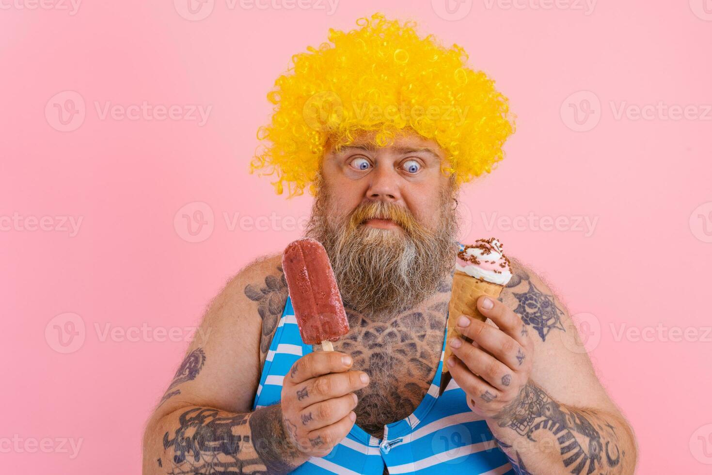 Fat man with beard and wig eats a popsicle and an icecream photo