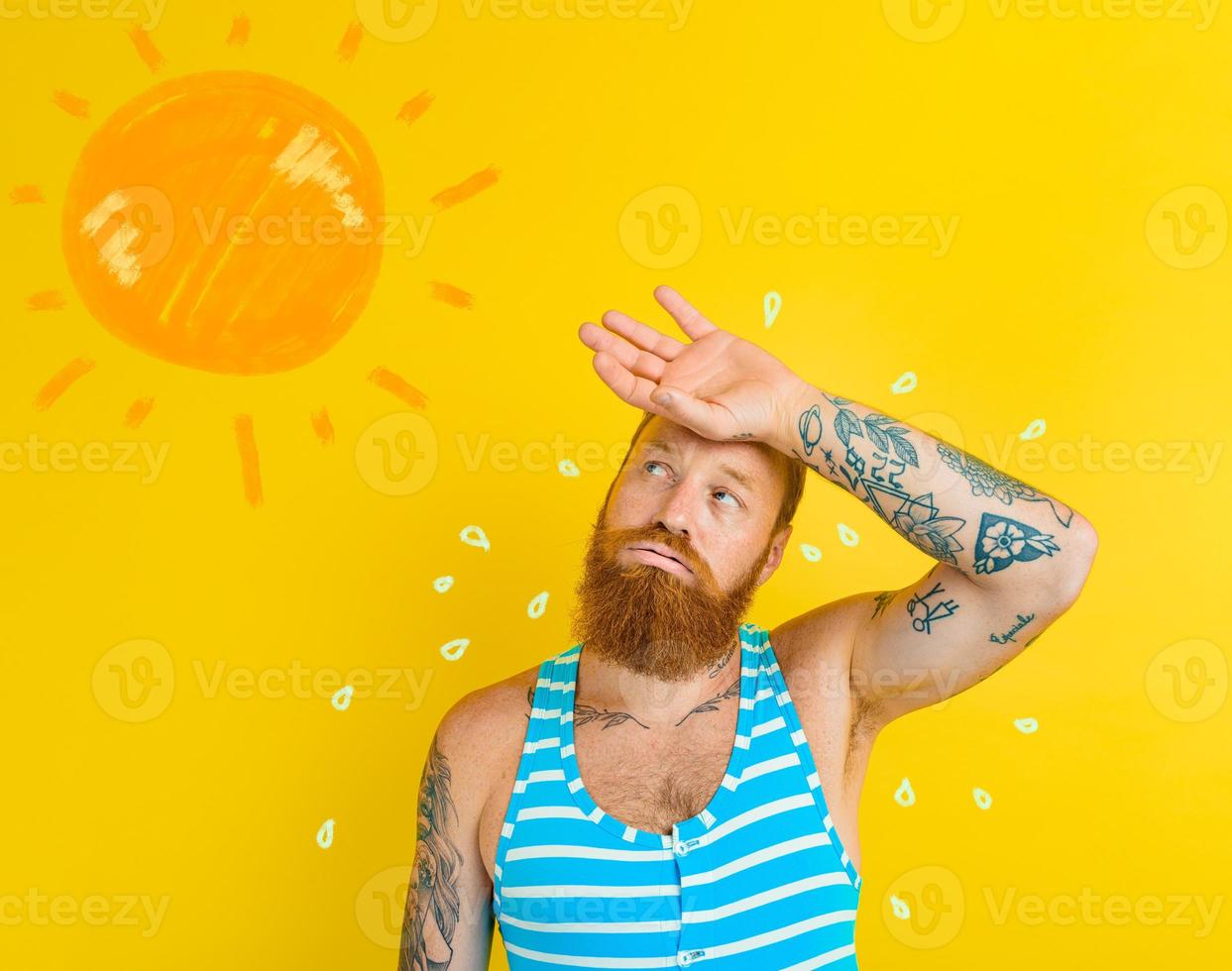 hombre en traje de baño suda debido a también caliente foto
