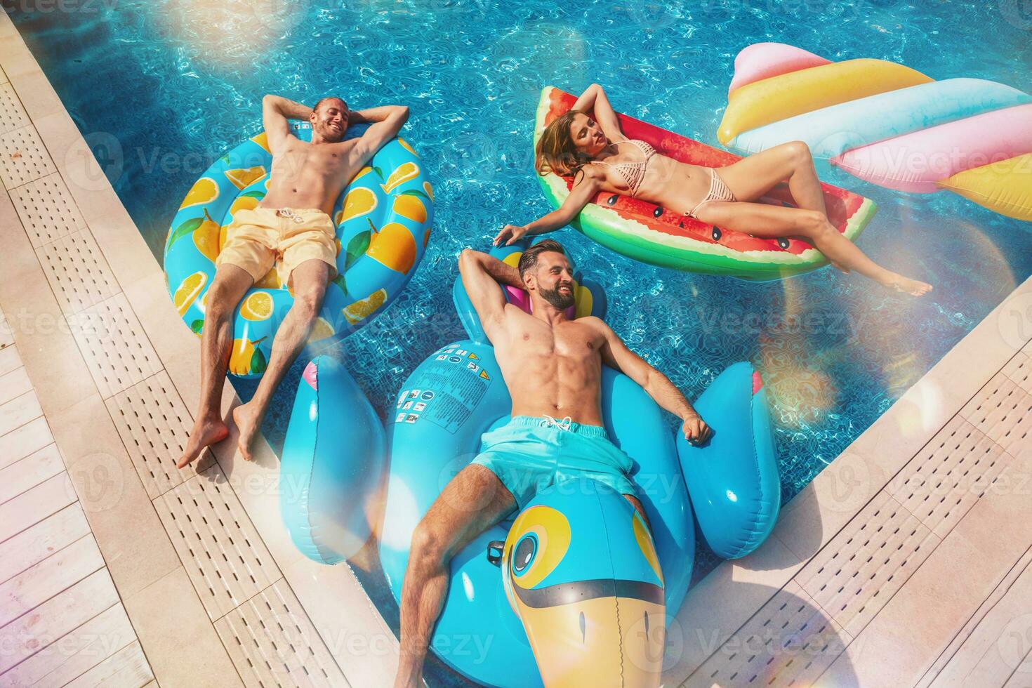 Friends in swimsuit in the pool getting a tan photo