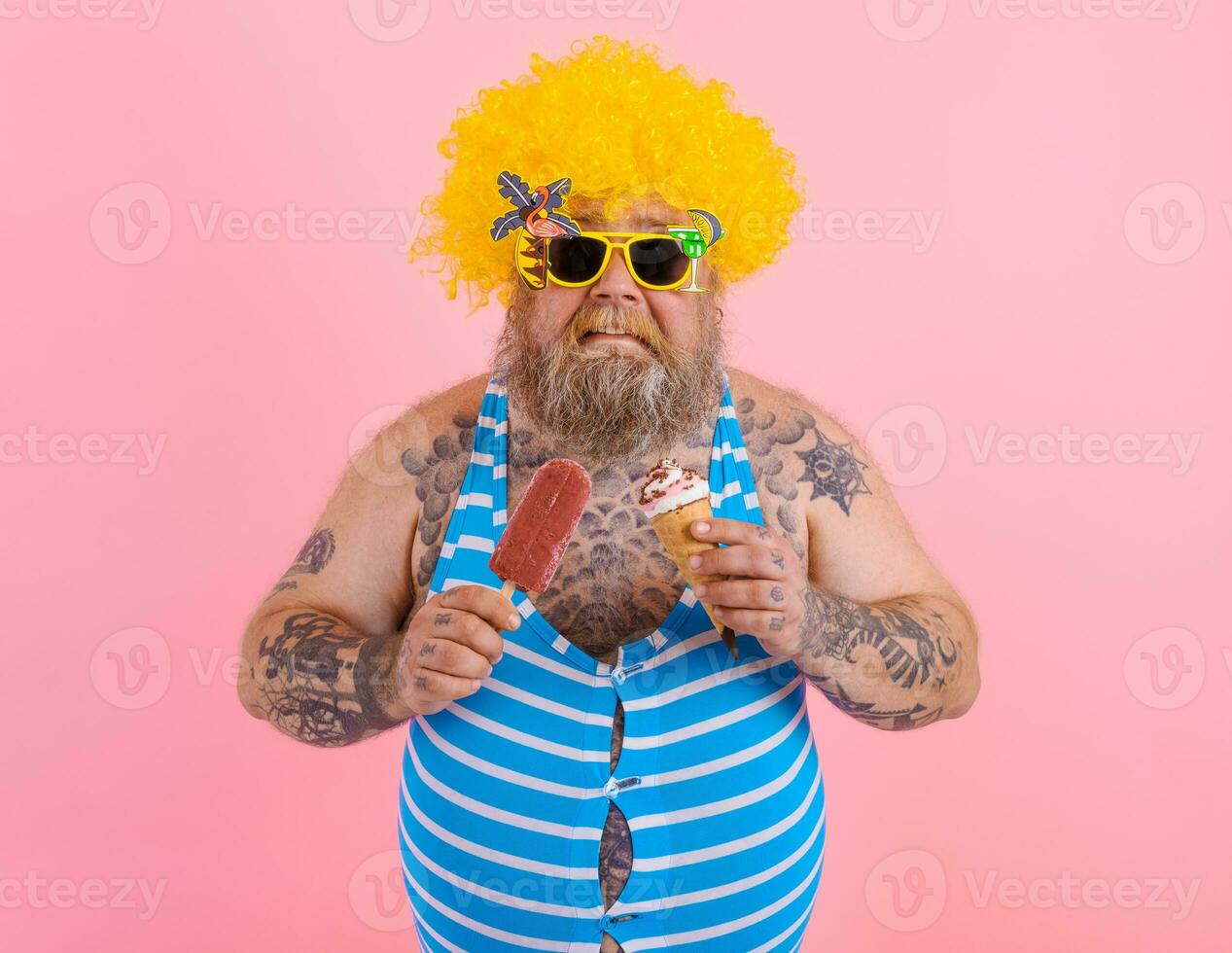 Fat man with beard and wig eats a popsicle and an icecream photo