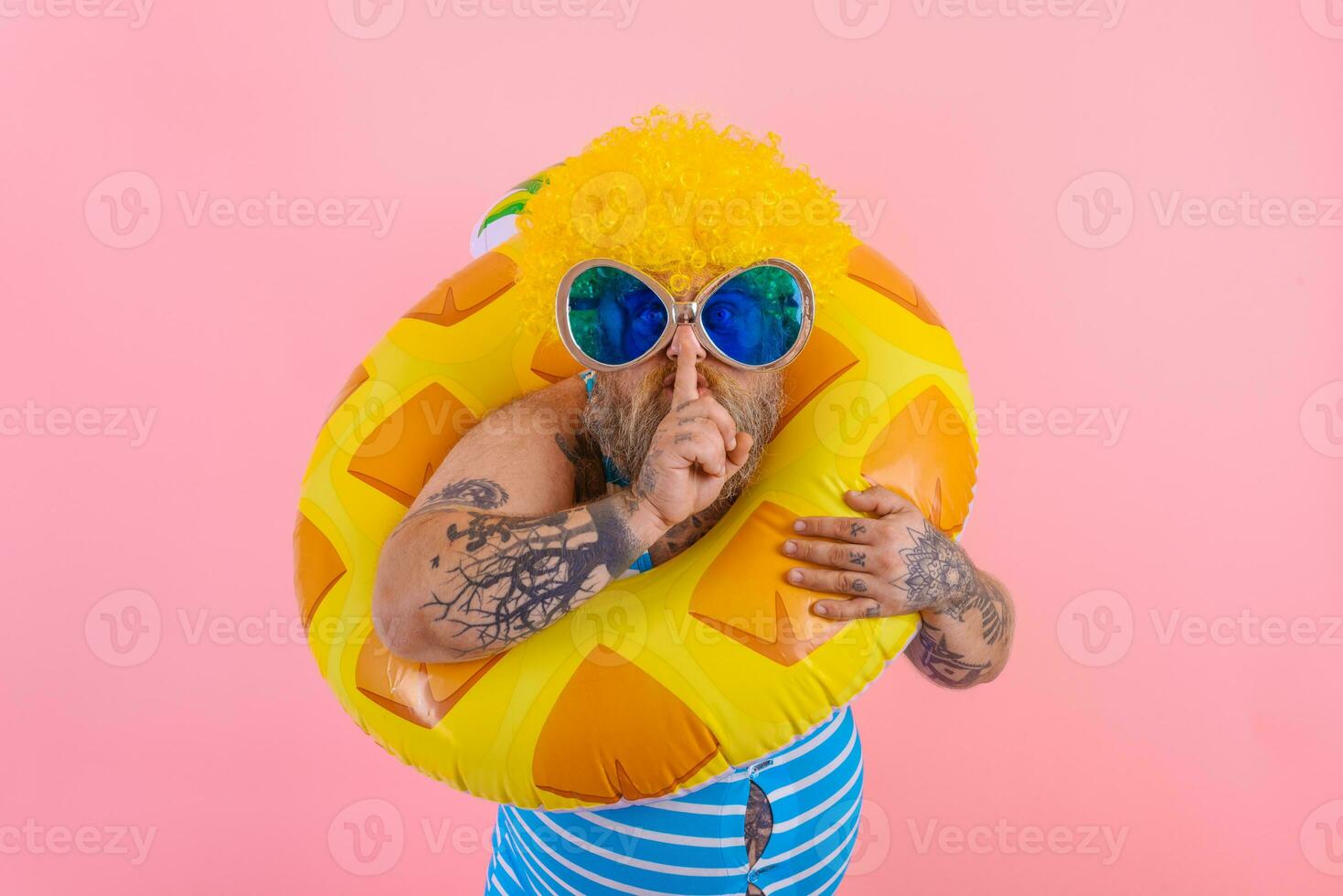 Fat man with wig in head is ready to swim with a donut lifesaver photo