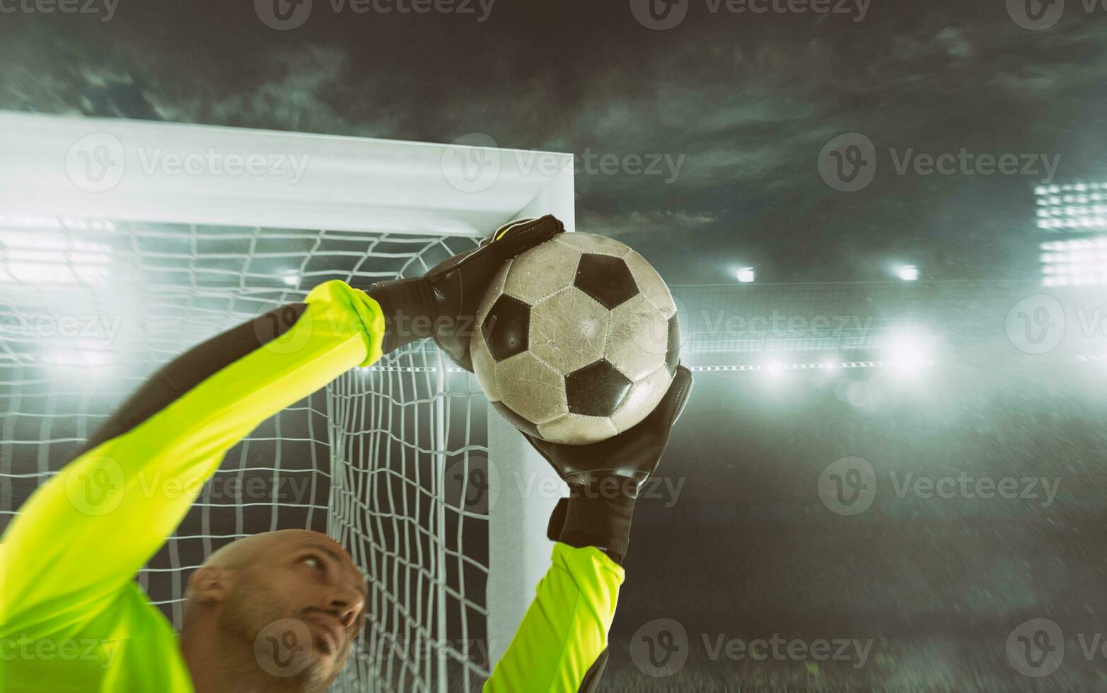 Close up of a soccer goalkeeper saving the ball at the corner of the goalposts photo