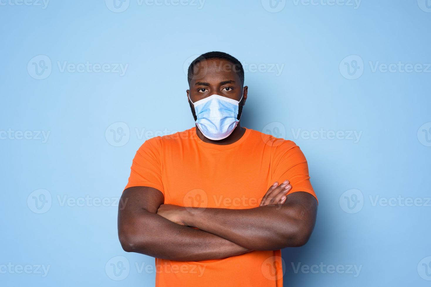 Man with face mask has a lot of questions and doubts about covid 19. cyan background photo