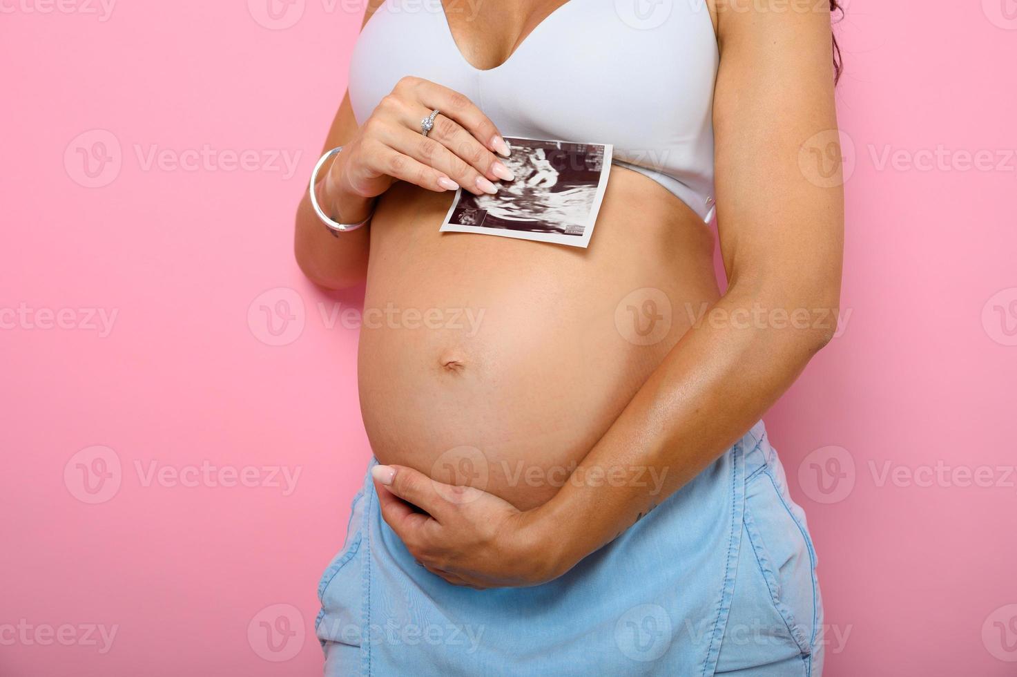 Pregnant mom shows an ultrasound of her son photo