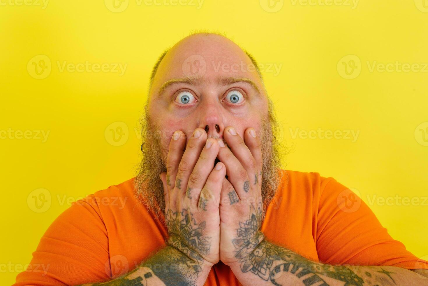 Man with beard and tattoos is worried about something photo