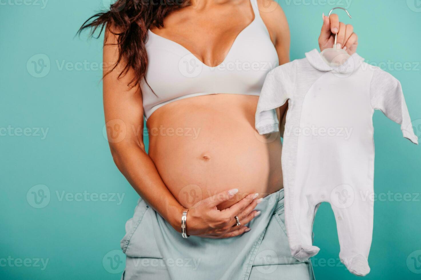 Pregnant mom prepares the clothes for the baby photo