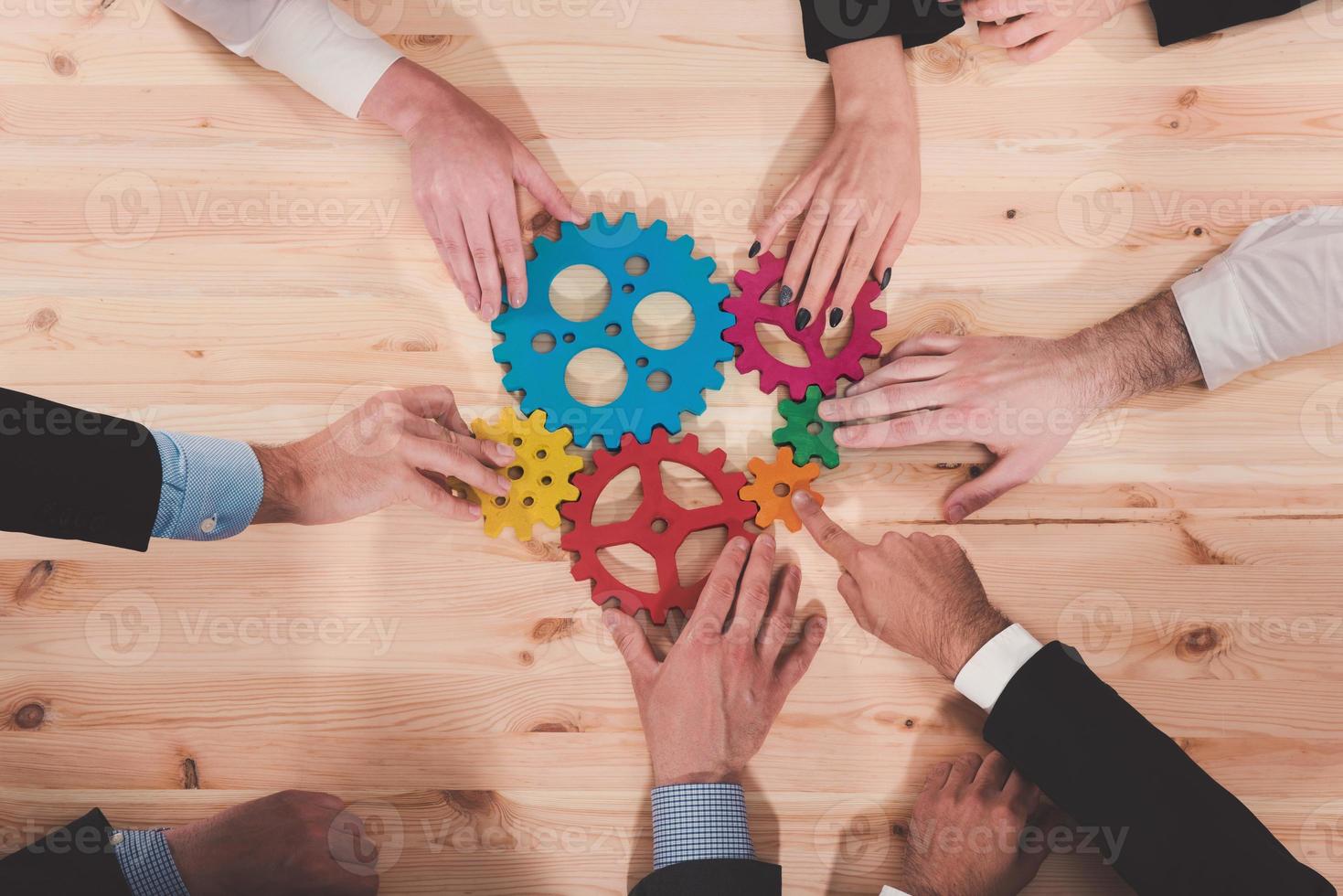 Business team connect pieces of gears. Teamwork, partnership and integration concept photo