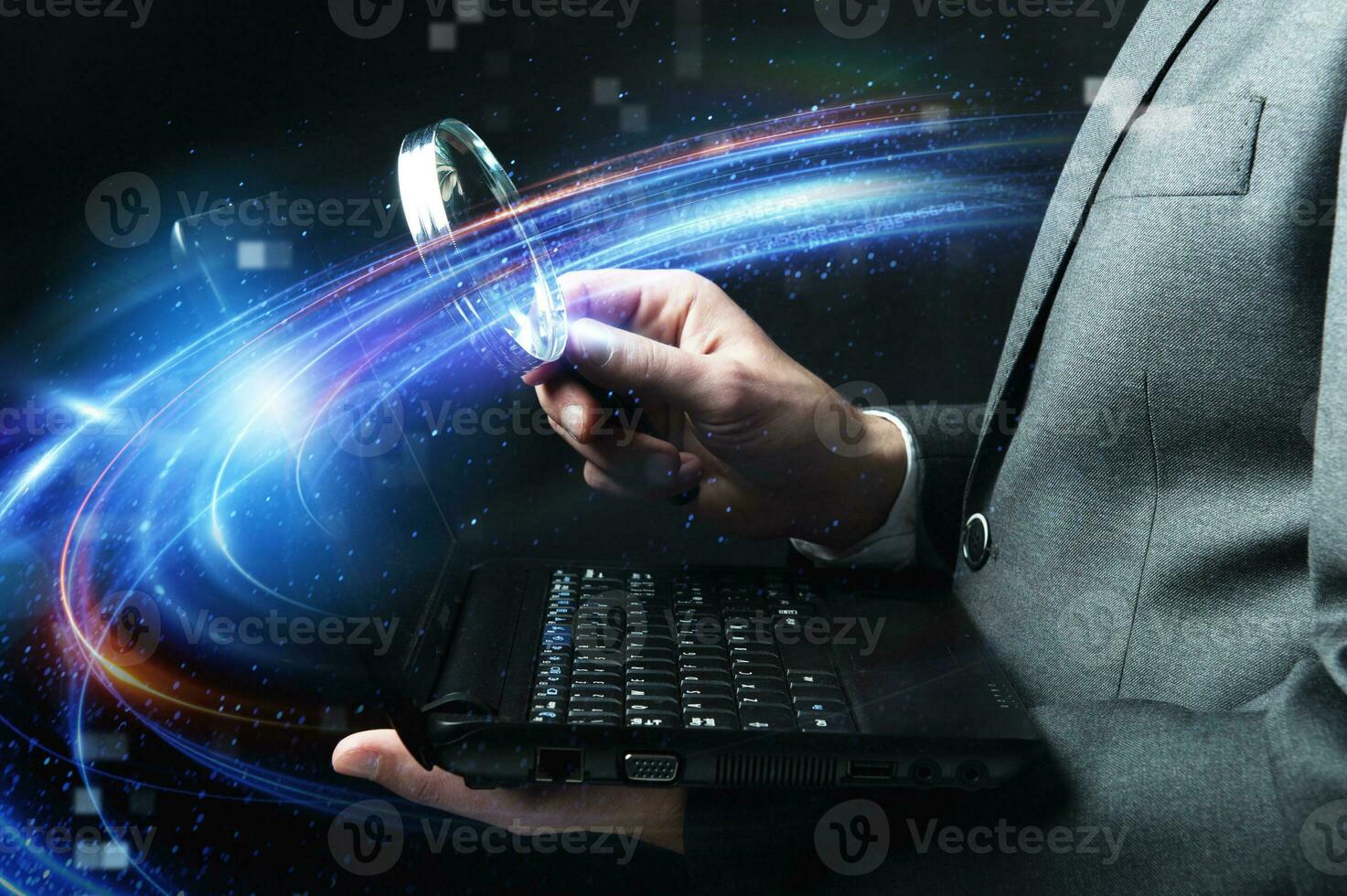 Businessman examines a laptop with a magnifying glass. Concept of internet security. photo