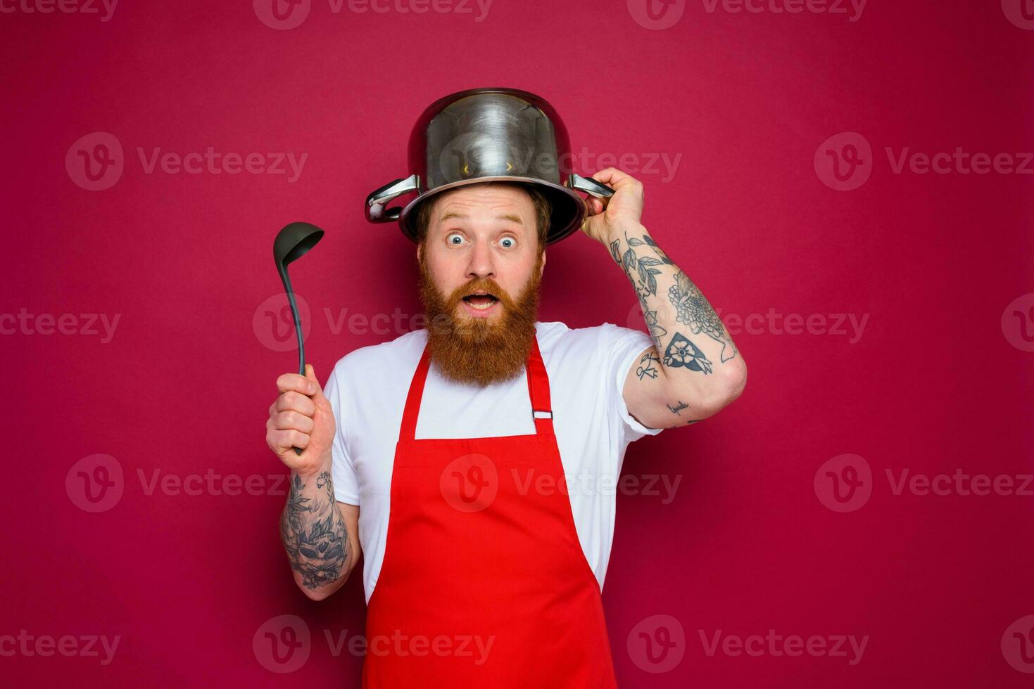 asombrado cocinero con barba y rojo delantal obras de teatro con maceta foto