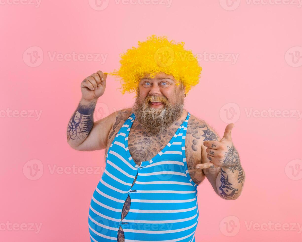 Happy man with yellow wig and swimsuit is ready to the summer photo