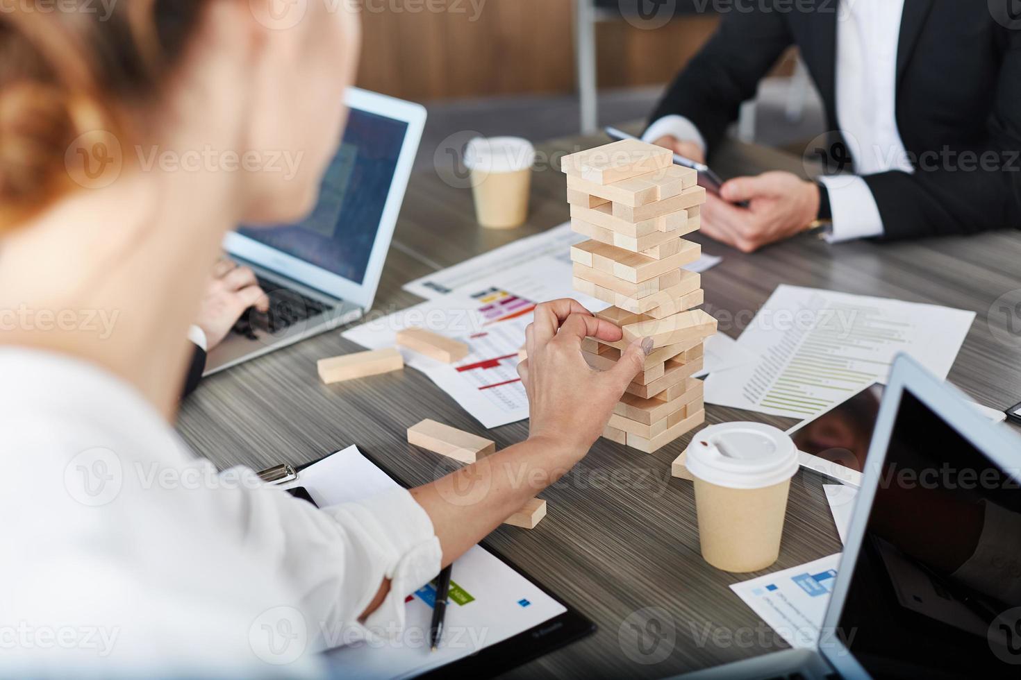 Team of business people build a wooden construction. concept of teamwork and partnership photo