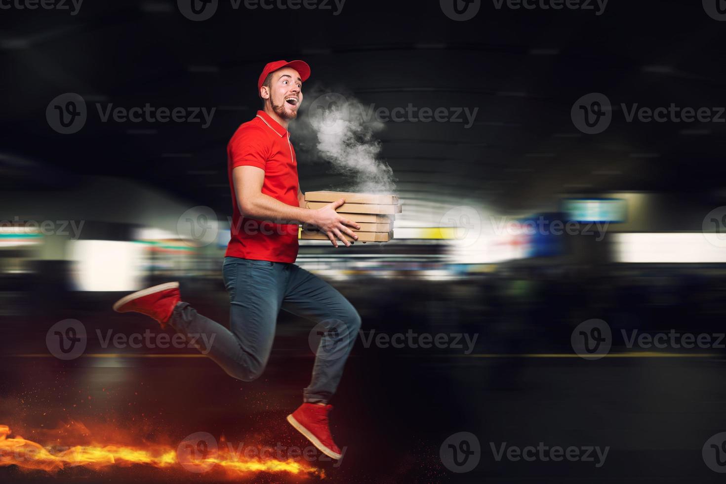 Messenger in red uniform runs on foot really fast to deliver quickly hot pizzas just baked photo