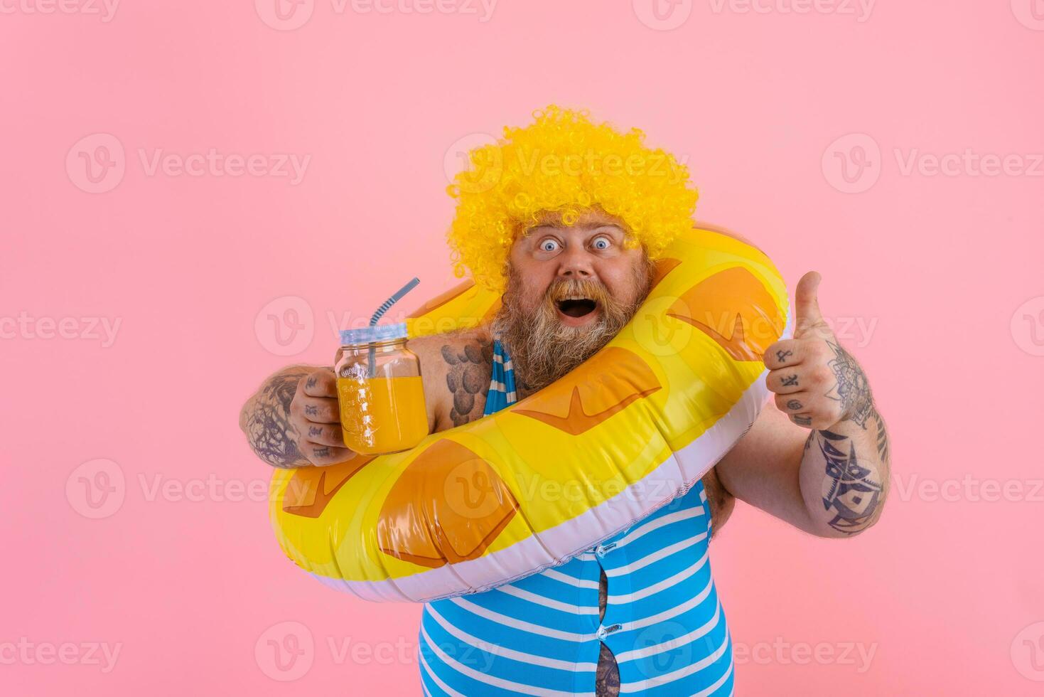 Fat happy man with wig in head is ready to swim with a donut lifesaver photo