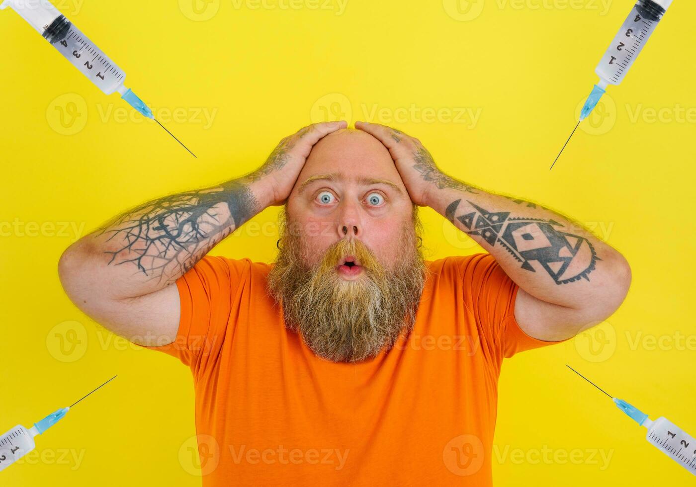 Afraid man with beard and tattoos is worried about the covid-19 vaccine photo