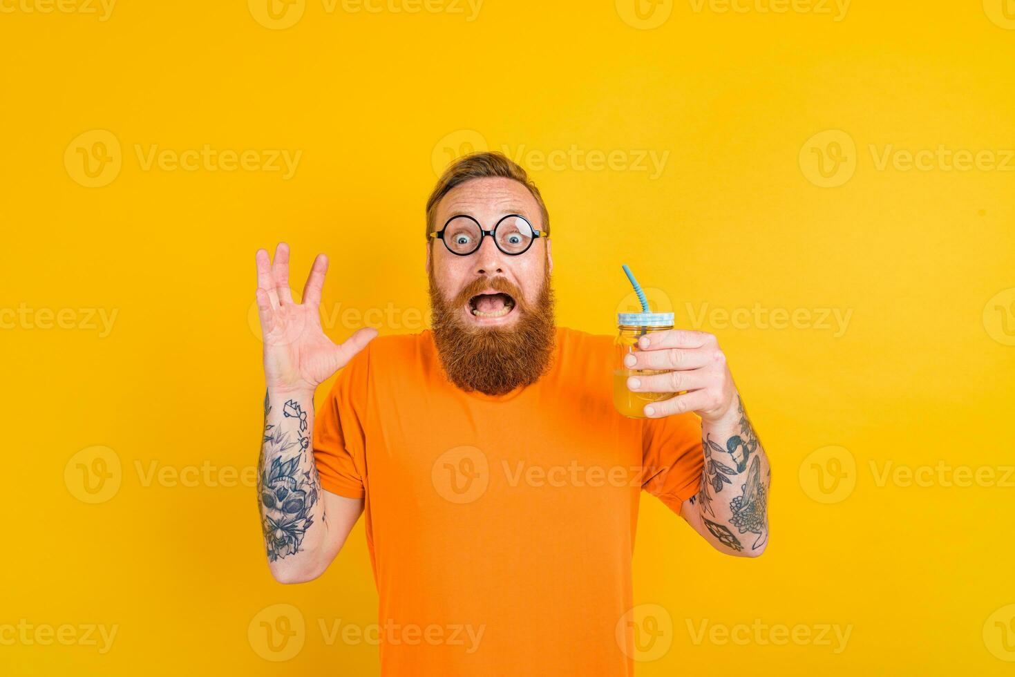 Nerd afraid man with glasses drinks a fruit juice photo
