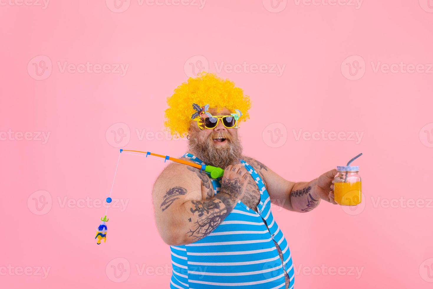 Fat happy man with beard and sunglasses have fun with the fishing pole photo