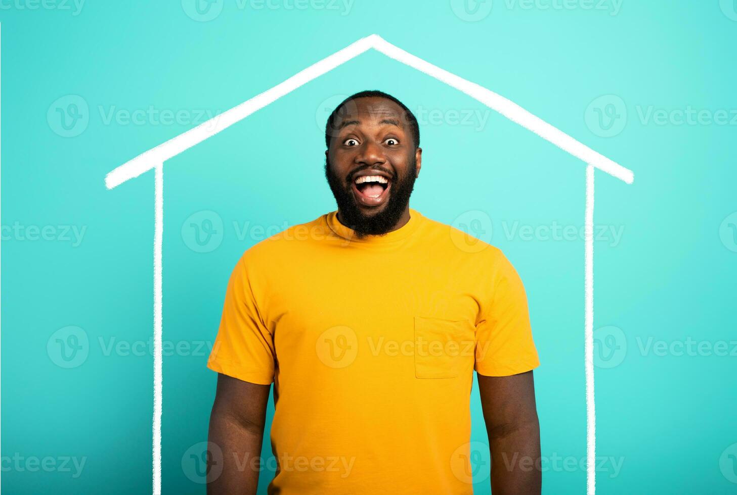 Man is amazed to have bought a house. Cyan background. photo
