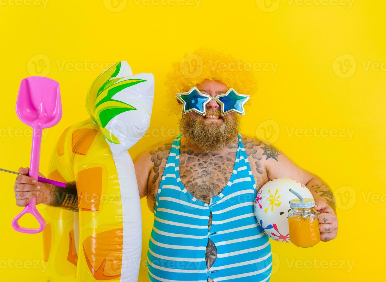 Fat happy man with wig in head is ready to swim with a donut lifesaver photo