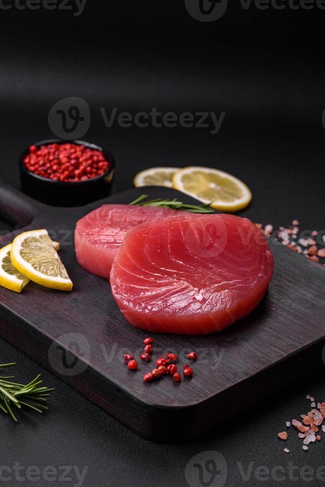 Two fresh slices of raw tuna fillet with spices and herbs photo