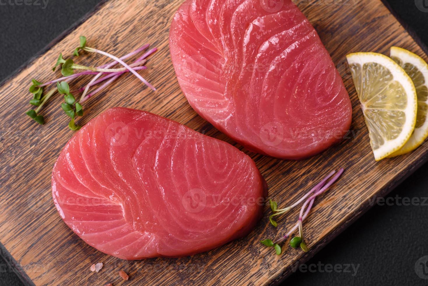 Two fresh slices of raw tuna fillet with spices and herbs photo