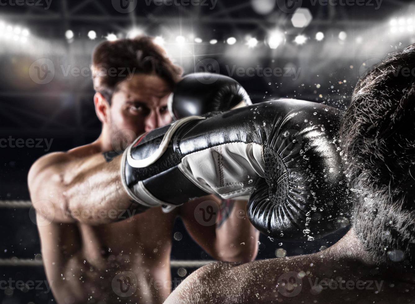 Boxer in a boxe competition beats his opponent photo