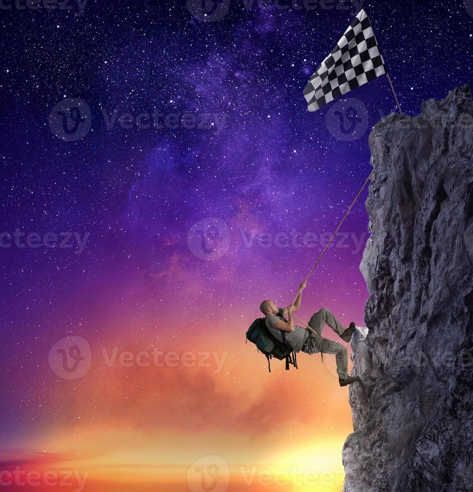 Businessman climb a mountain to get the flag. Achievement business goal and difficult career concept photo