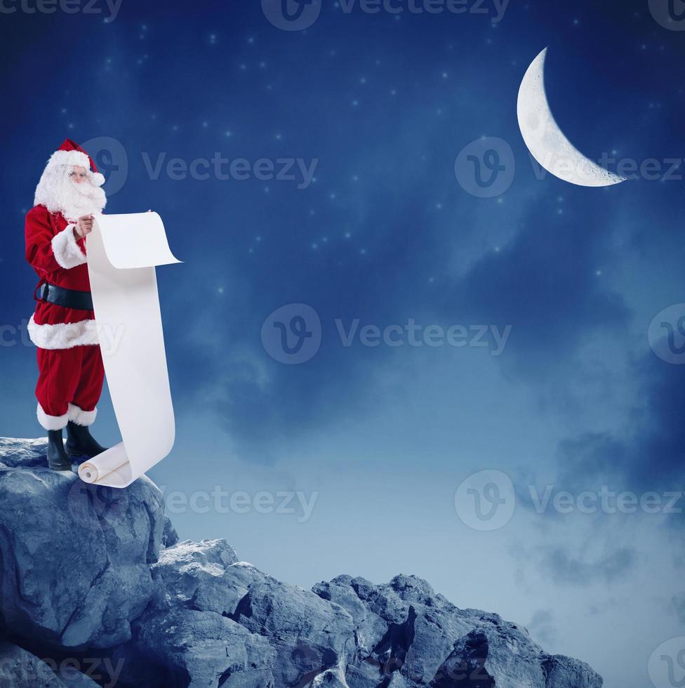 Papa Noel claus lee el lista de regalos en el pico de un montaña debajo el Luna foto