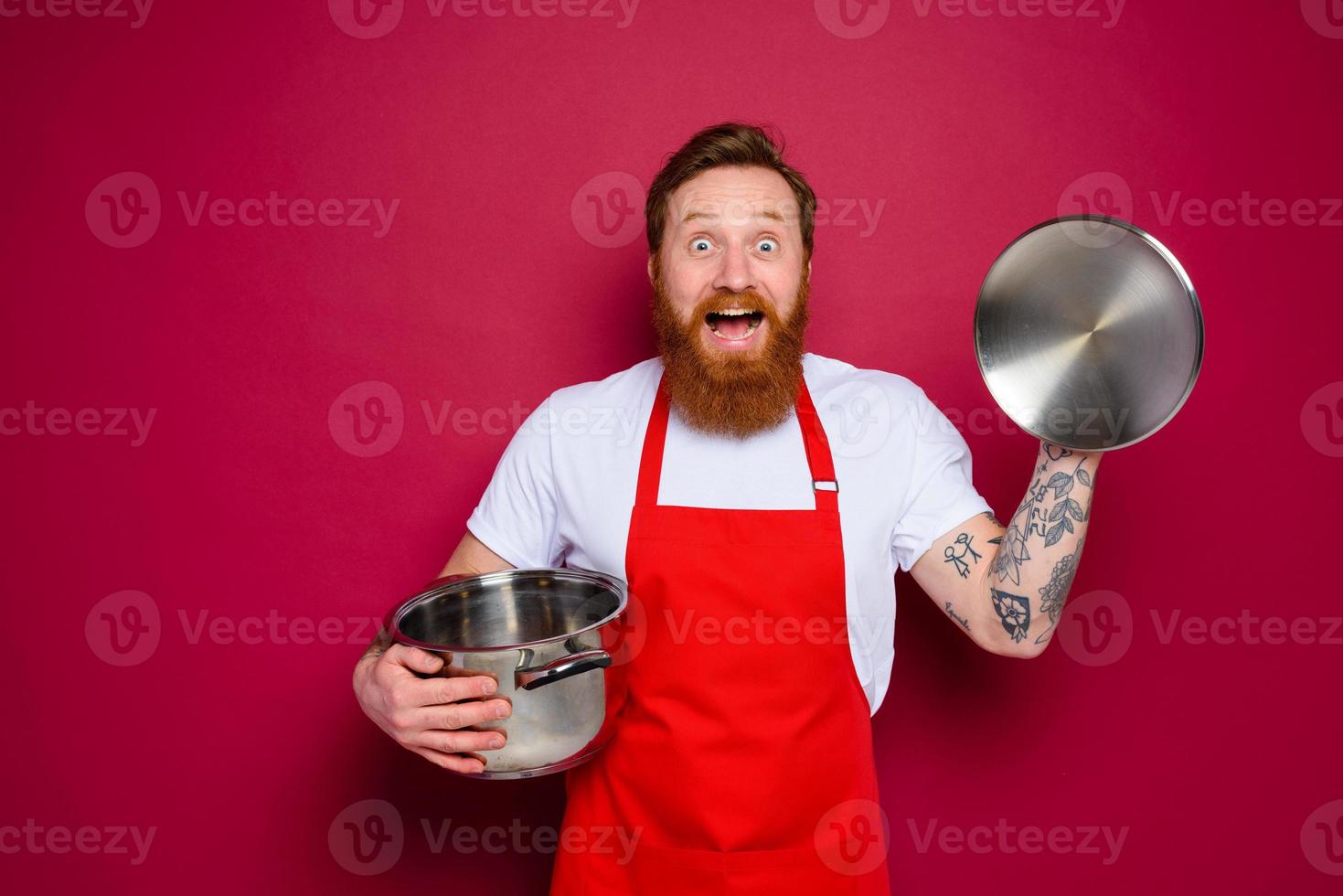 surprised chef with beard and red apron is ready to cook photo