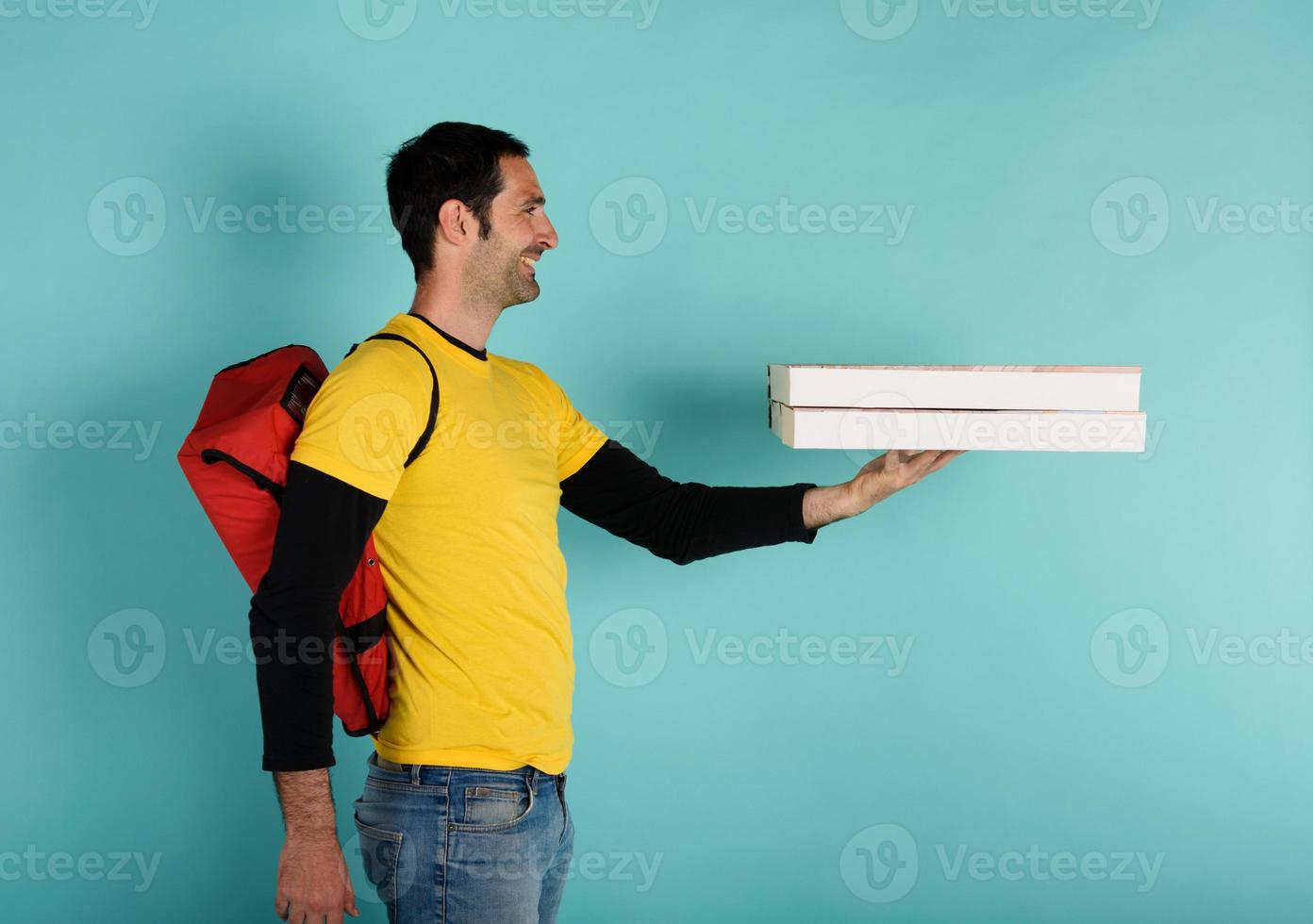 Deliveryman holds bizza boxes ready to be delivered . cyan background photo