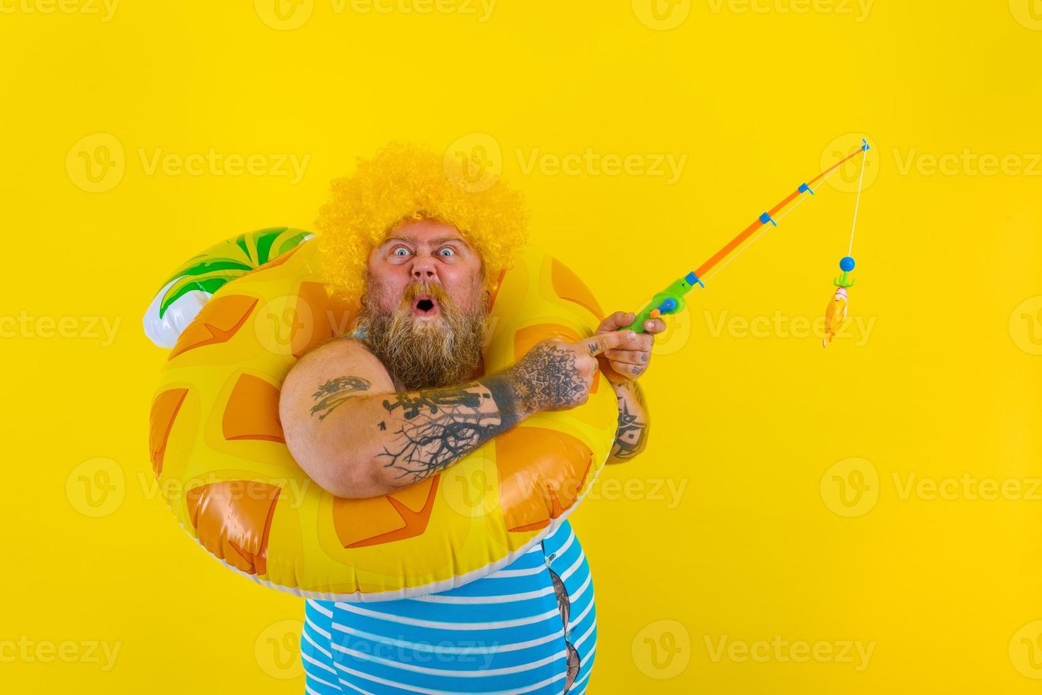 Fat delusion man with wig in head plays with the fishing rod photo