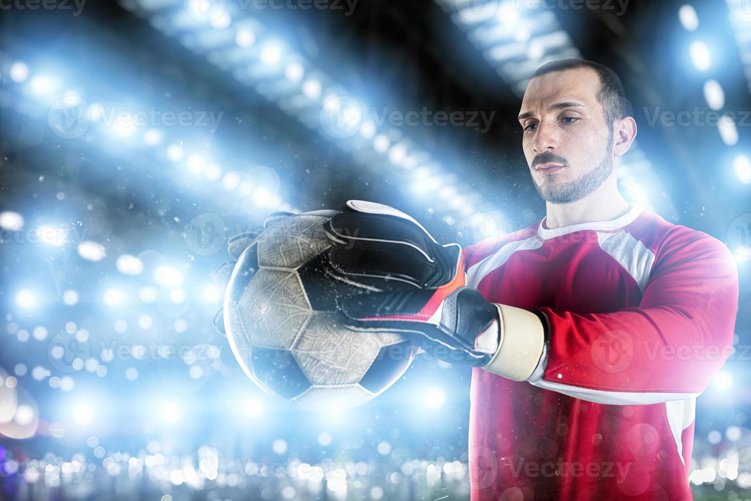 Goalkeeper holds the ball in the stadium during a football game. photo