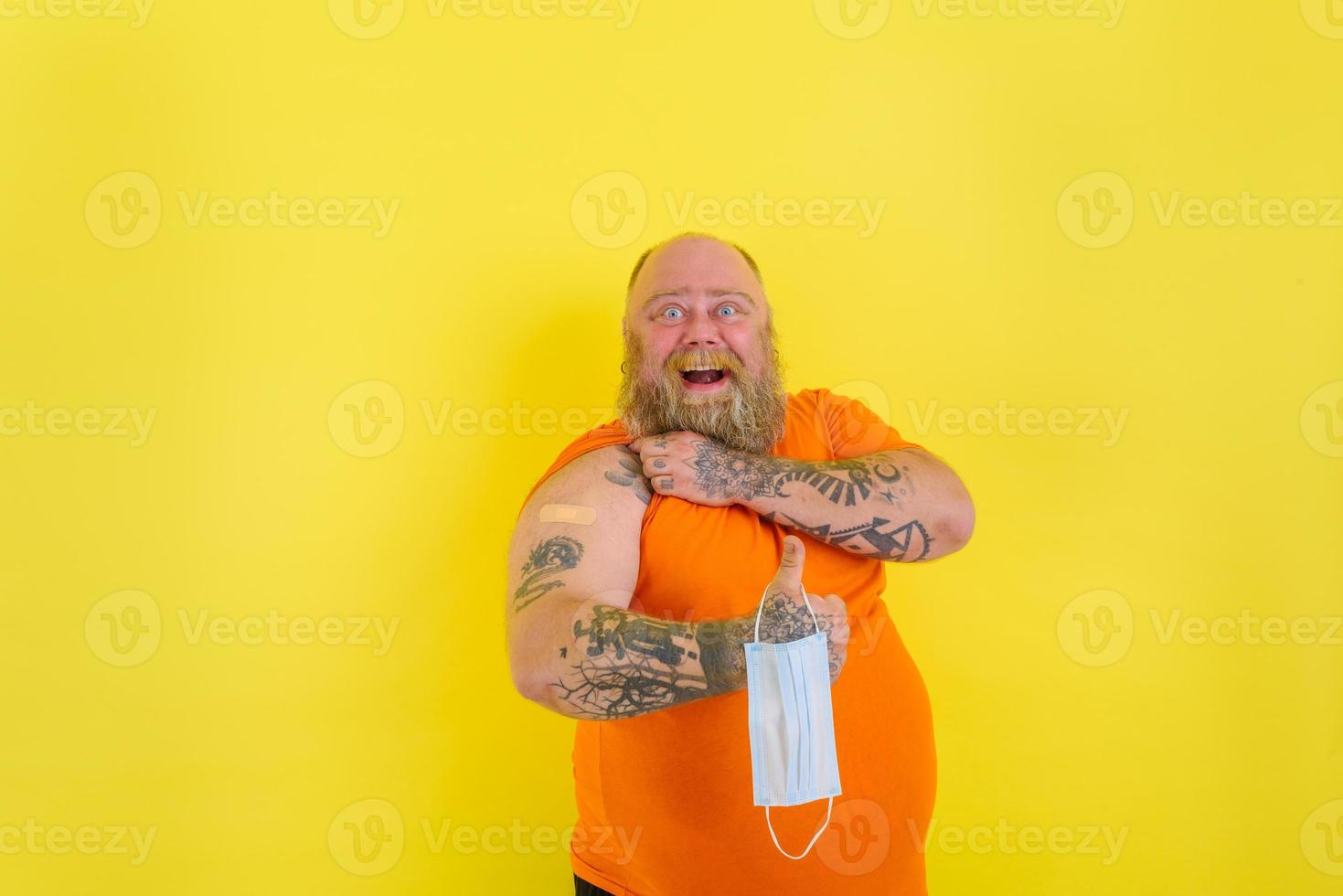 Happy man with beard and tattoos did the vaccine against covid-19 photo