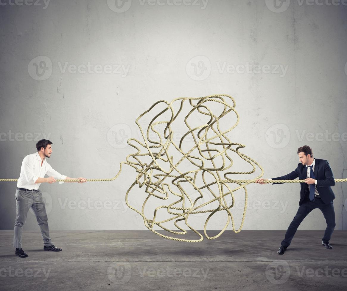 Businessmen try to solve a tangled rope. Concept of partnership photo