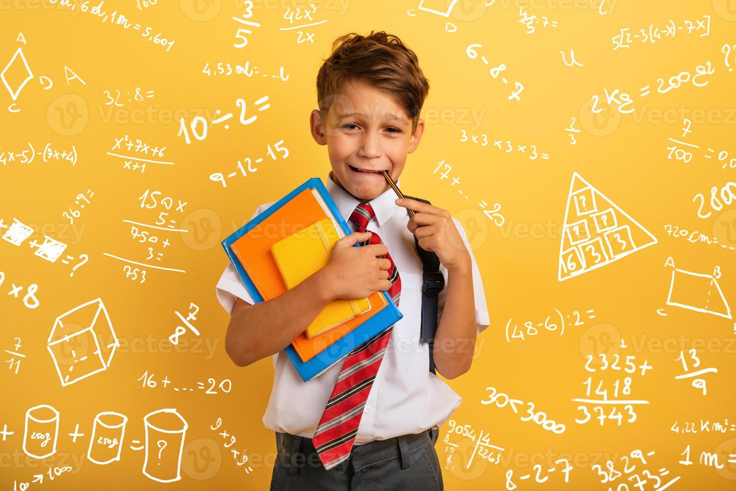 Child cries because he has a lot of school homework. Emotional expression. Yellow background photo