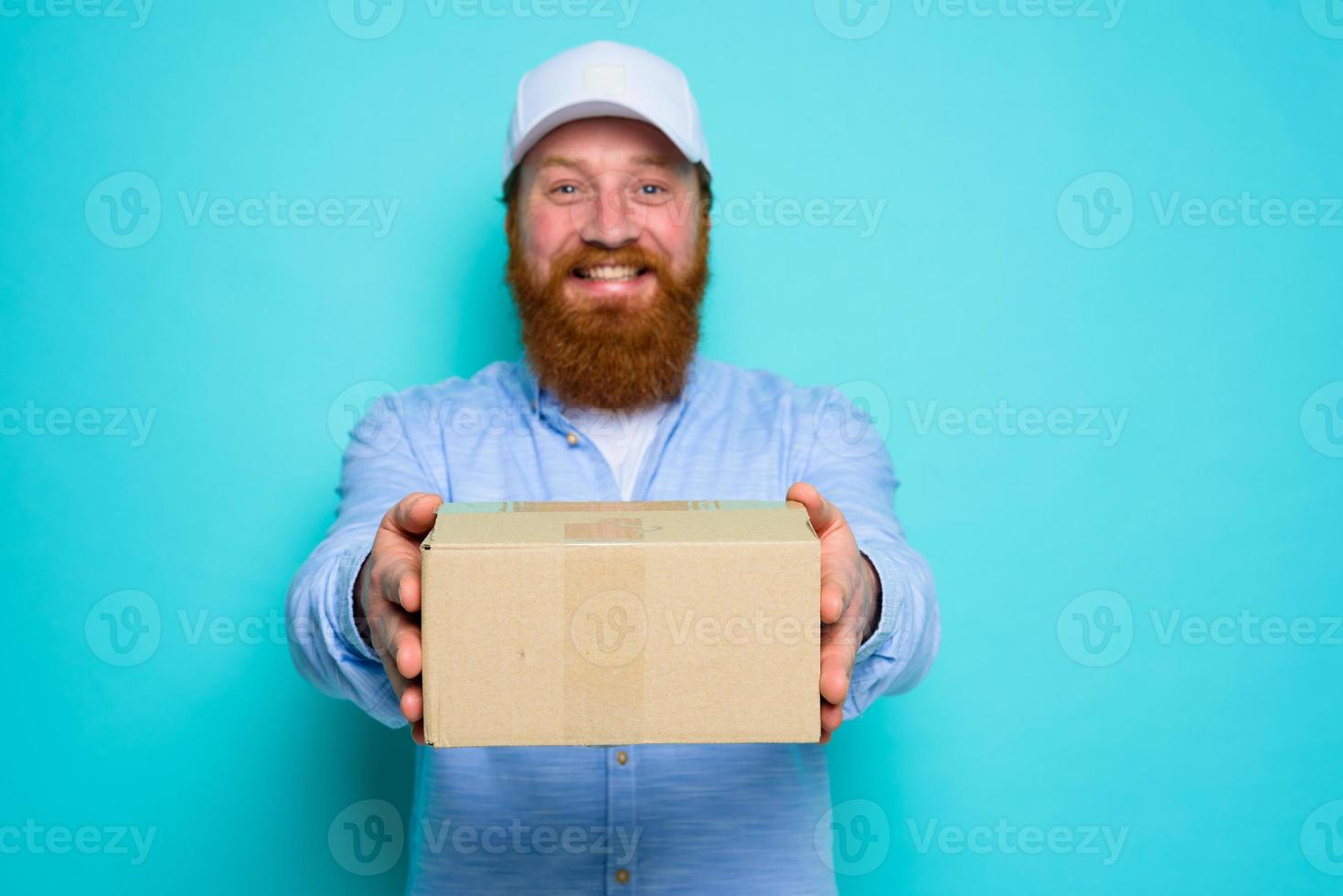 Courier with hat is happy to deliver a carton box photo