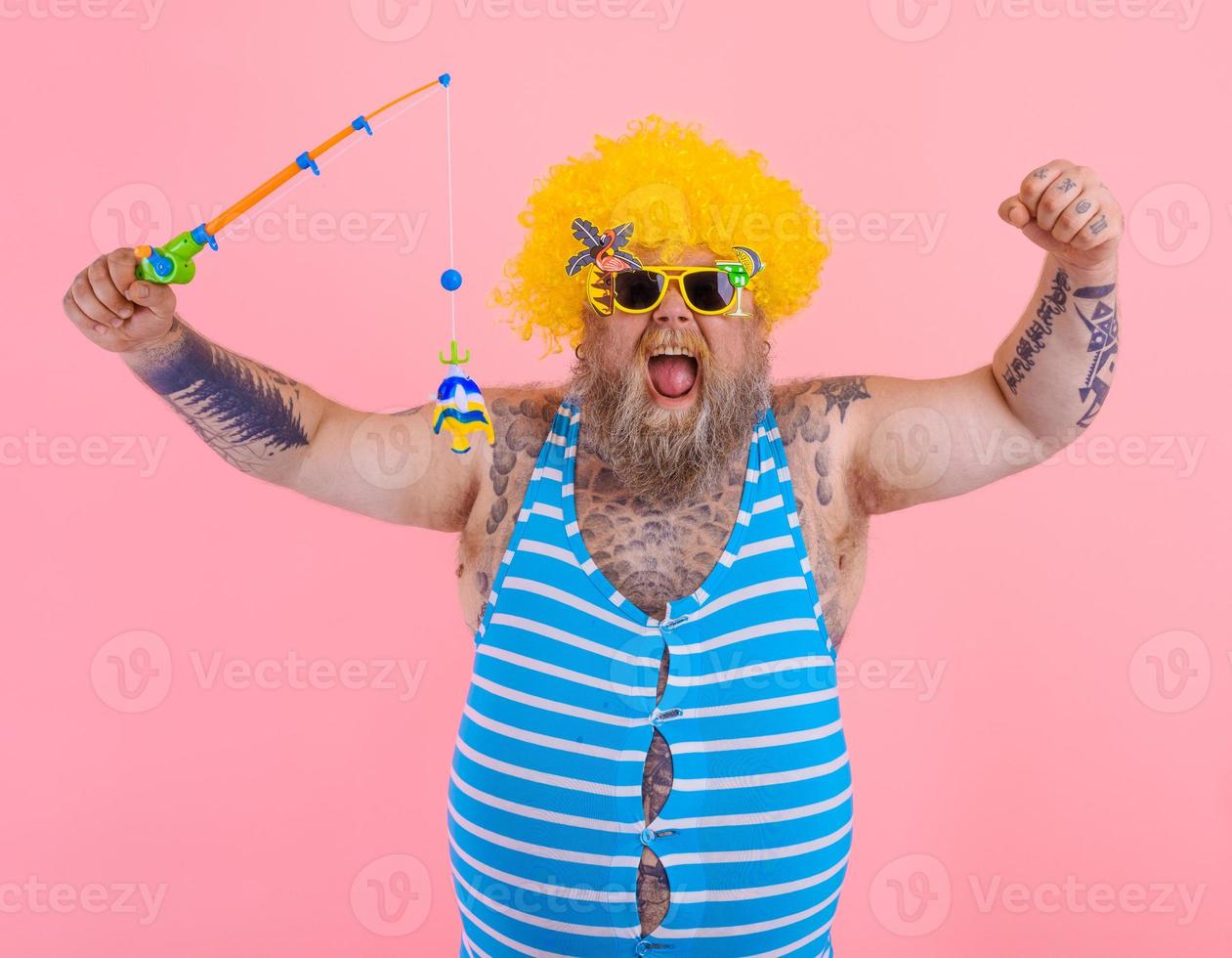 Fat happy man with beard and sunglasses have fun with the fishing pole photo