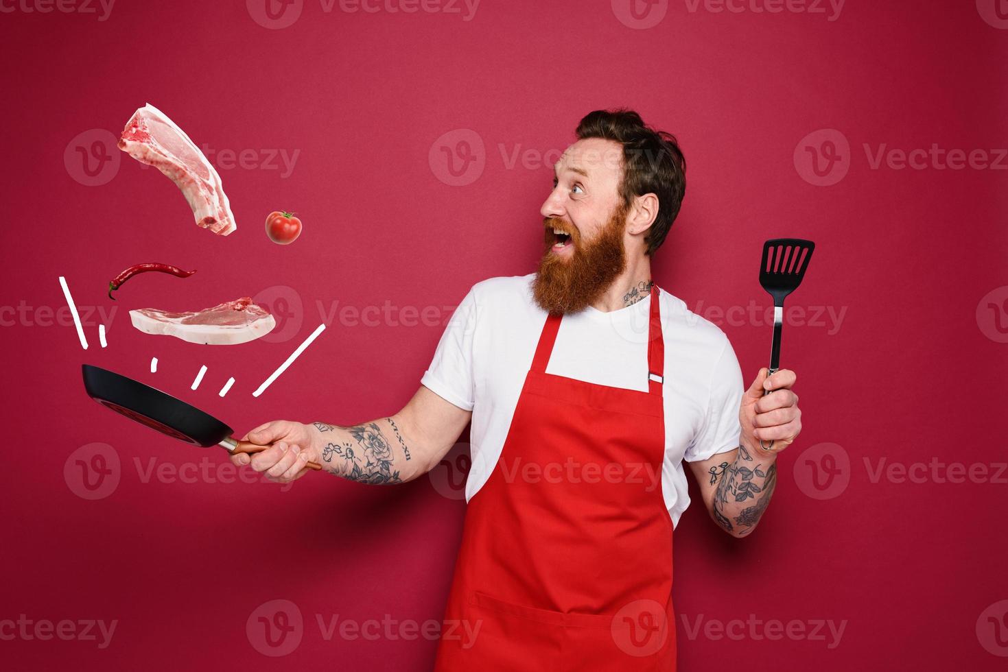 Happy chef cooks a new creative recipe. red background photo