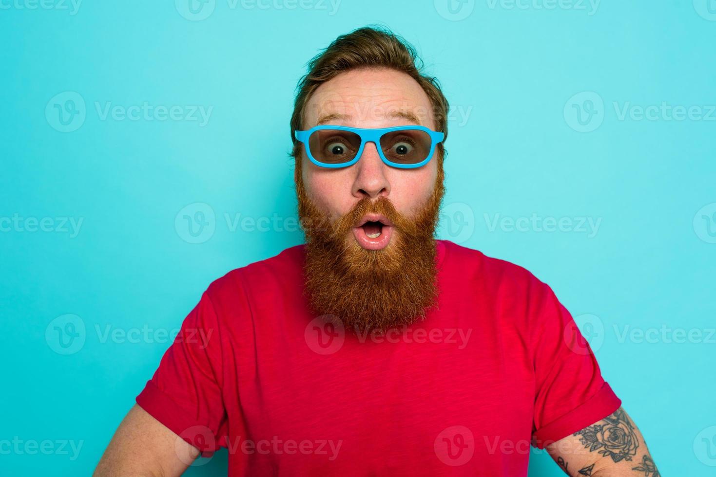 Man with beard and sunglasses is wondered and happy photo