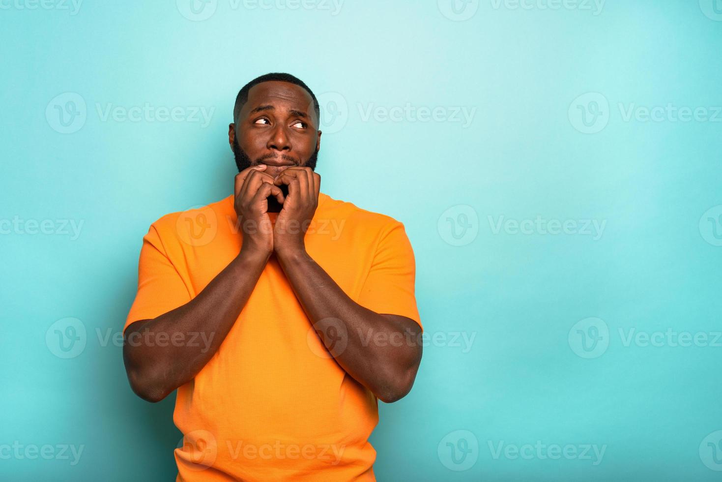 Man is afraid about something over a cyan background photo
