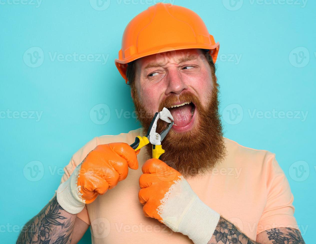 Incompetent worker acts like a dentist and removes a tooth. cyan background photo