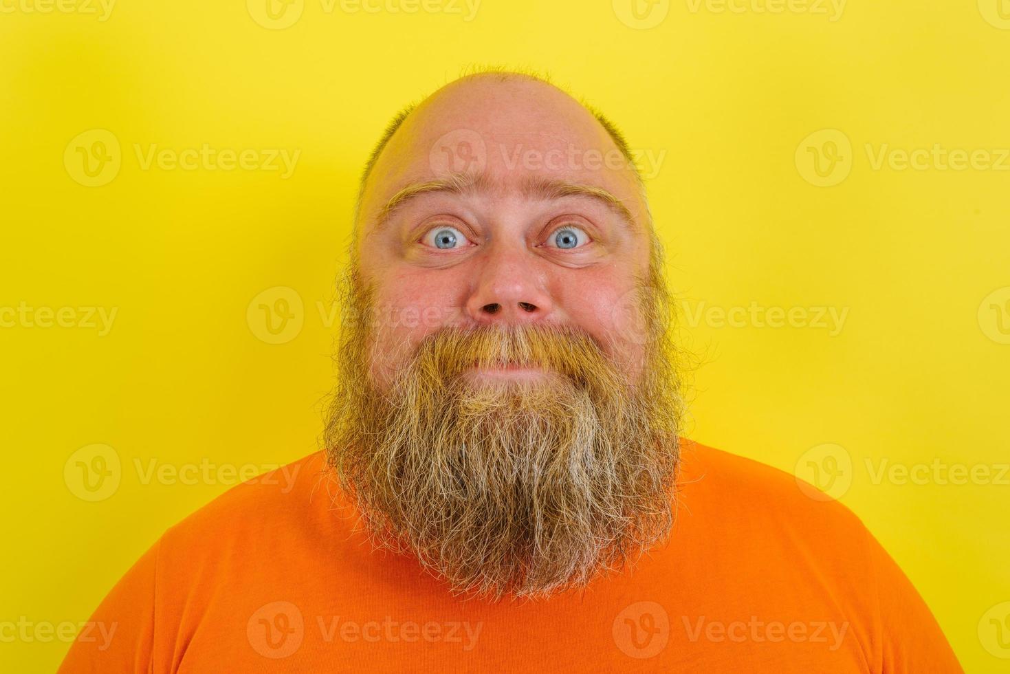 Happy man with beard and tattoos is happy about something photo