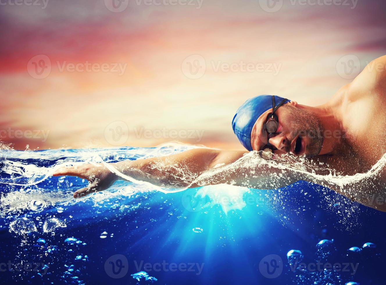 Boy swims in a blue deep water photo