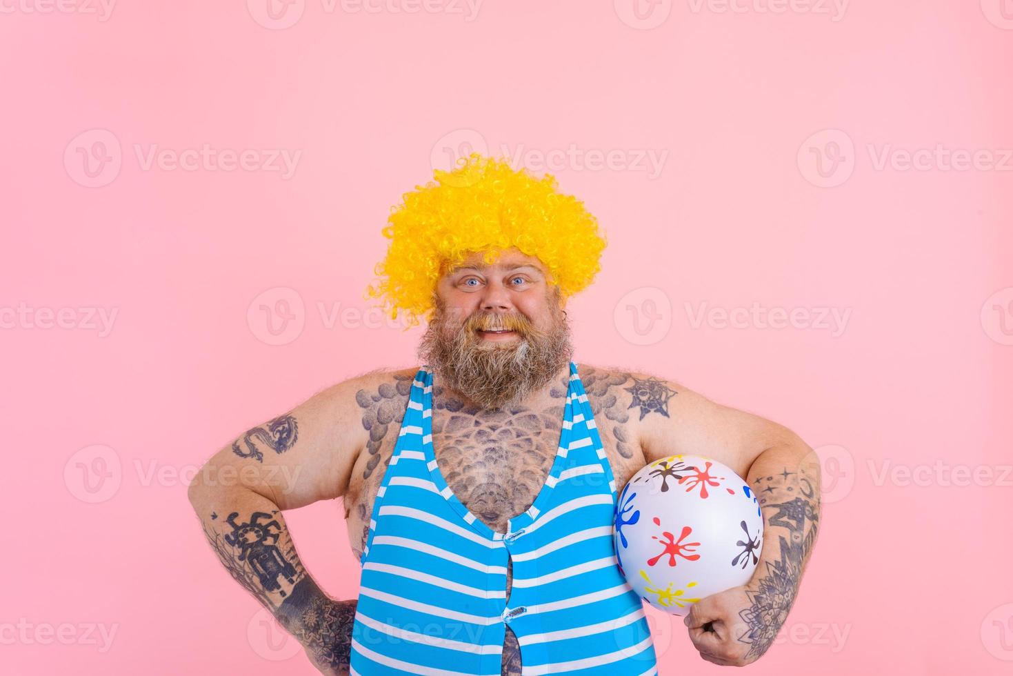 Fat happy man with beard and wig play with the ball photo
