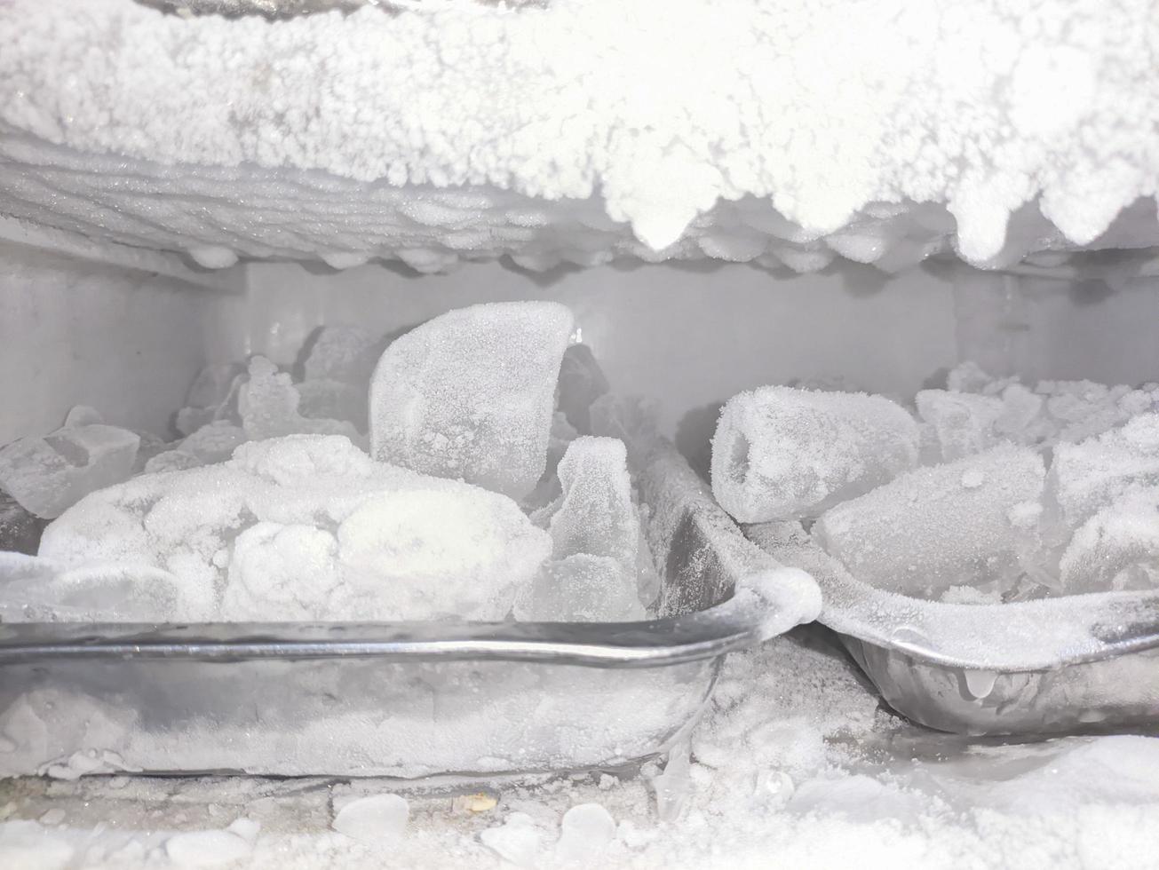 the inside of the freezer filled with ice cubes photo