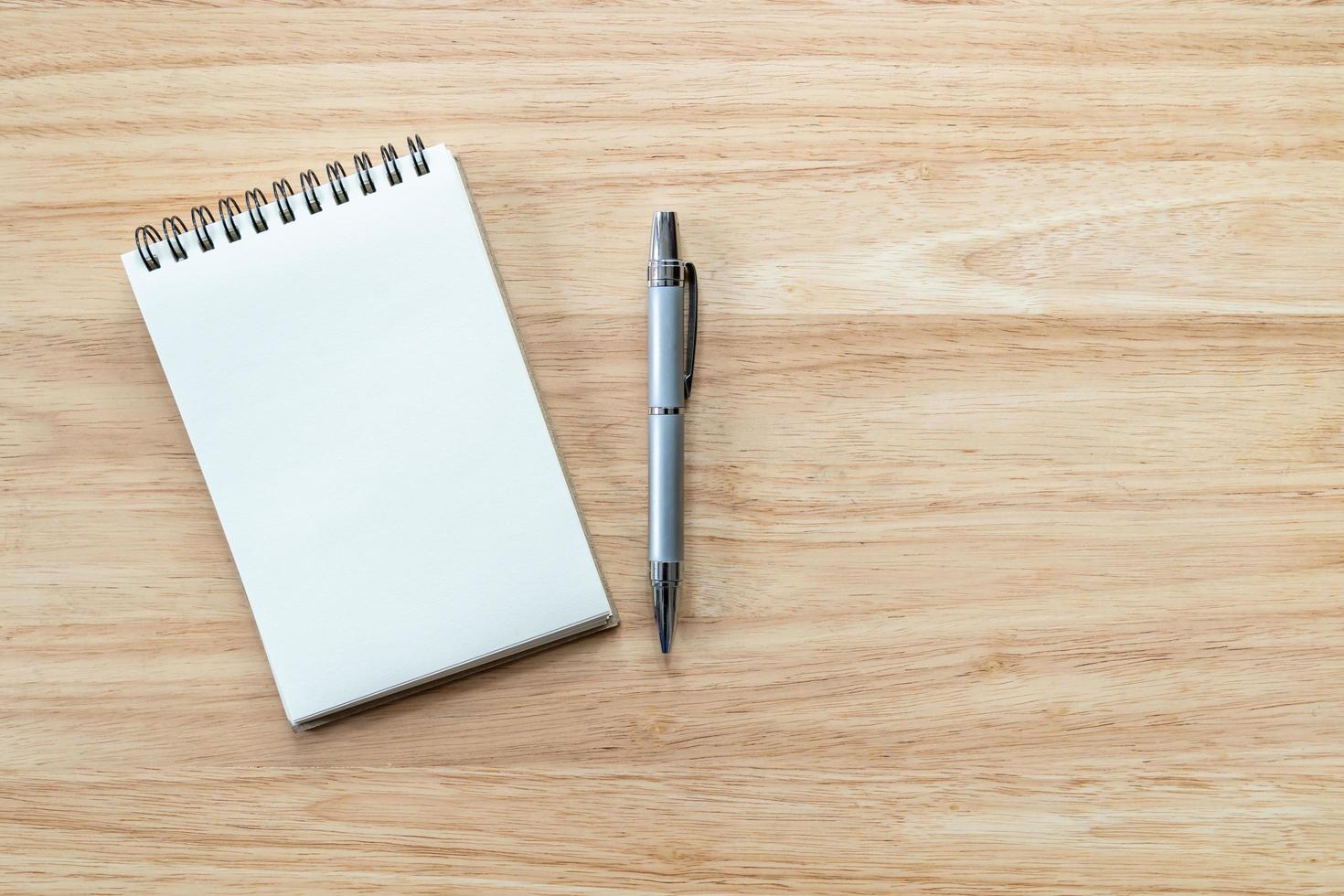 Blank notebook paper and pencil on wood table background with copy space. photo