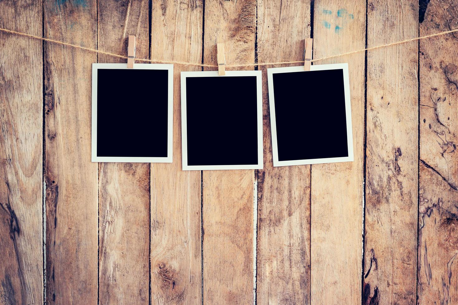 three photo frame hanging on clothesline and rope with wooden background.