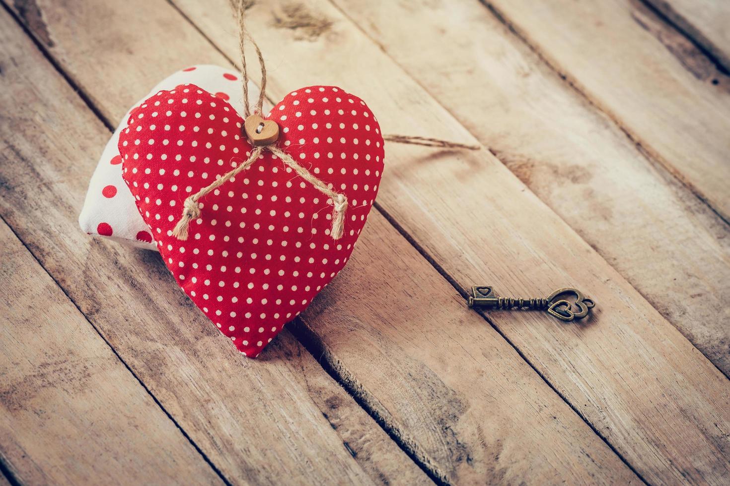 Heart fabric and vintage key on wood table background. photo
